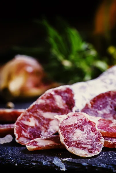 Jerked włoskie salami z rozmarynem, przyprawy, oliwki i olej. — Zdjęcie stockowe