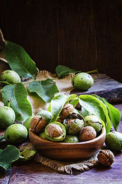 Fresh walnuts in a green shell with leaves