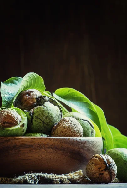 Frische Walnüsse in einer grünen Schale mit Blättern — Stockfoto