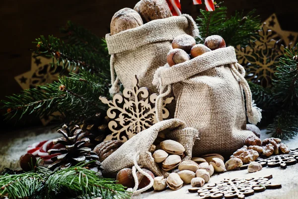 Neujahrs- oder Weihnachtskomposition mit Walnüssen, Haselnüssen, Pistazien in Leinensäcken — Stockfoto