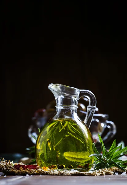 Olivenöl mit Rosmarin und Gewürzen im Glaskrug — Stockfoto