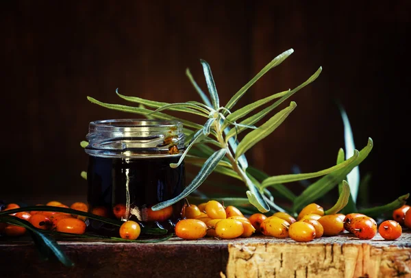 Curative sea buckthorn oil and fresh berries — Stock Photo, Image