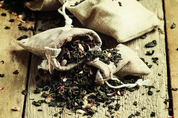 Chá verde seco com pétalas de flores em sacos de lona — Fotografia de Stock
