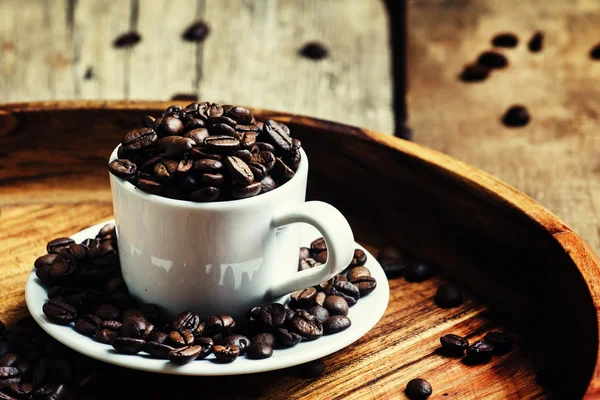 Granos de café tostado en una taza blanca — Foto de Stock
