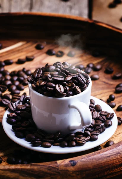 Granos de café tostado en una taza blanca —  Fotos de Stock