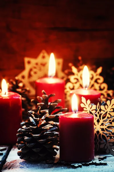 Burning red candles and pine cones with snowflakes — Stock Photo, Image