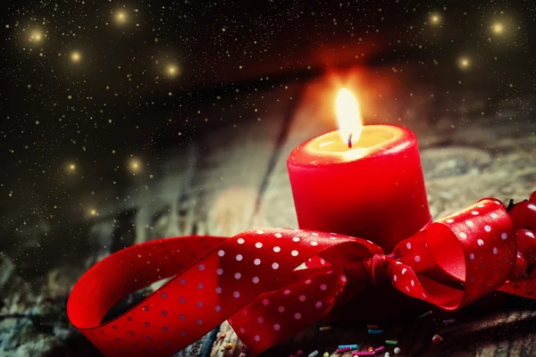 Burning candle with a red polka dot ribbon and berries — Stock Photo, Image