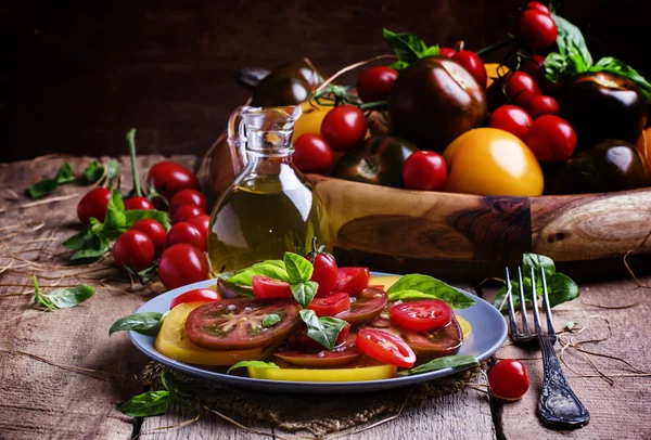Салат из разноцветных помидоров на тарелке — стоковое фото