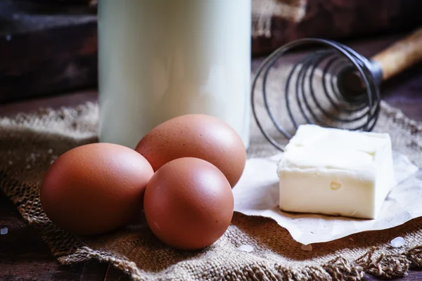 Huevos orgánicos frescos, leche y mantequilla, naturaleza muerta en estilo rústico —  Fotos de Stock