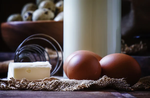 Fresh organic eggs, milk and butter, still life in rustic style