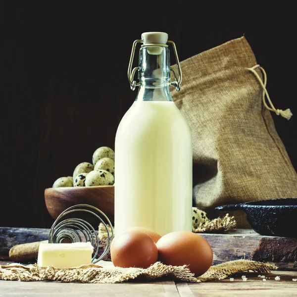 Fresh organic eggs, milk and butter, still life in rustic style