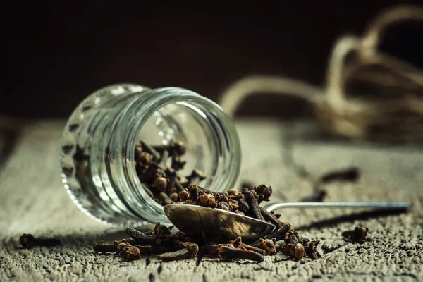 丁香枝，香料中的玻璃罐和银勺子 — 图库照片