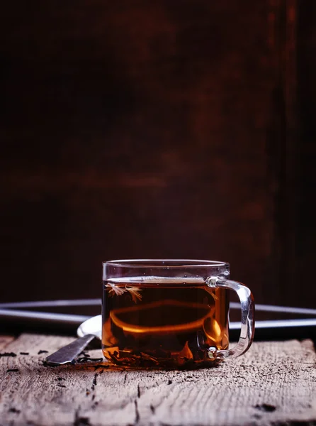 Černé teplé čaje s lžící a digitální tablet — Stock fotografie