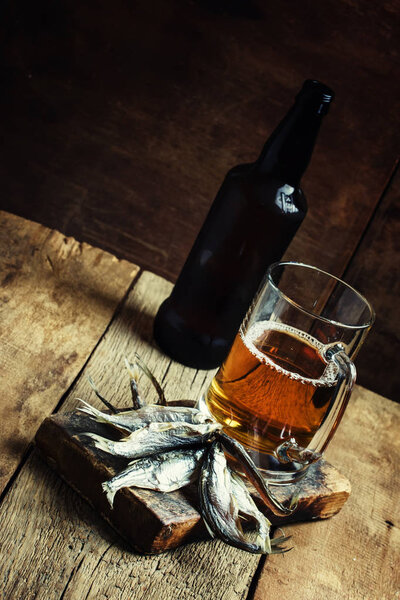 Beer and fish, dark wood background