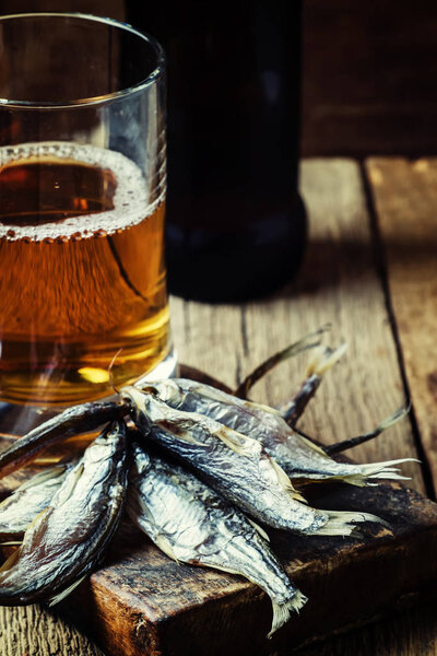 Beer and fish, dark wood background