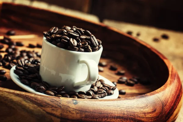 Kaffeebohnen in einer Tasse auf einem Tablett — Stockfoto