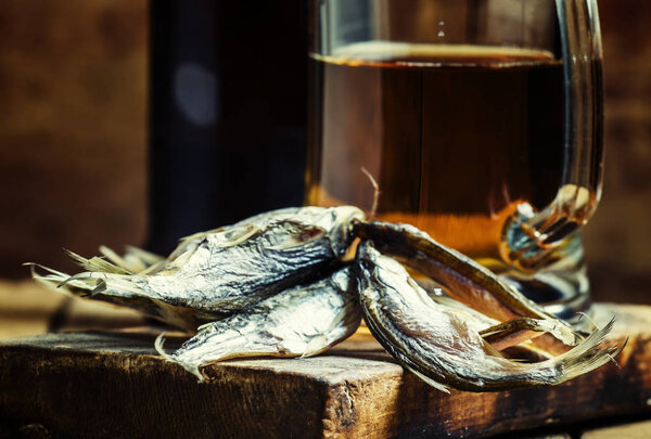 Beer and fish, dark wood background 