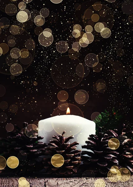 Christmas or New Year's composition with burning candle and pine cones — Stock Photo, Image