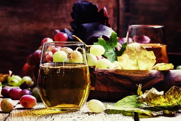 Sumo de uva em vidro e bagas com folhas — Fotografia de Stock