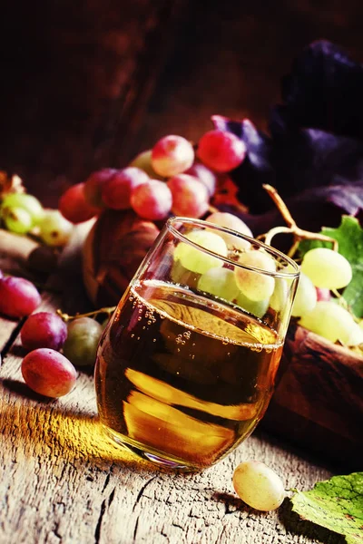 Виноградный сок в стакане и ягоды с листьями — стоковое фото