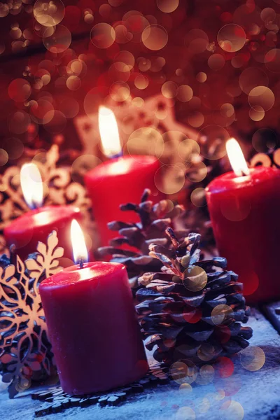 Κόκκινο αναμμένα κεριά με κουκουνάρια και νιφάδες χιονιού — Φωτογραφία Αρχείου
