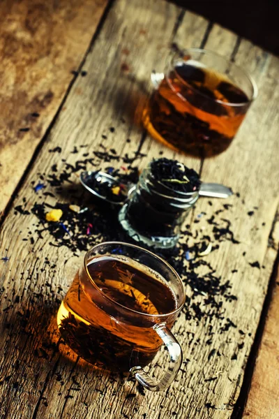 Zwarte thee met bloemen Korenbloem en gedroogde vruchten in glazen bekers — Stockfoto