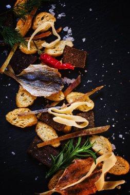 Kurutulmuş balık, kalamar ve kraker, taş koyu arka plan