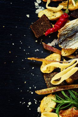 Kurutulmuş balık, kalamar ve kraker, taş koyu arka plan