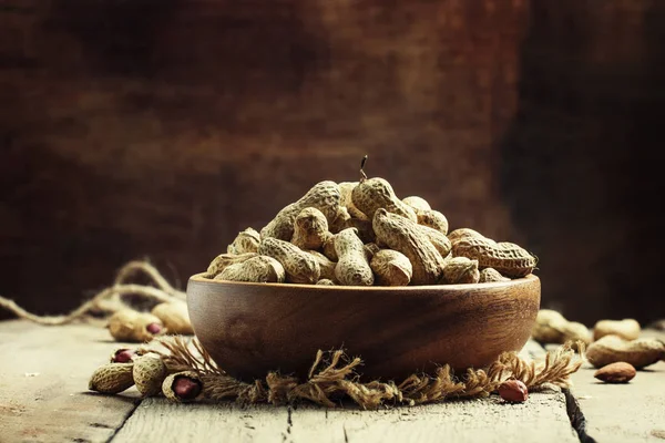Amendoim com casca, fundo de madeira vintage — Fotografia de Stock
