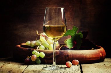 White wine in a glass with fall grapes clipart