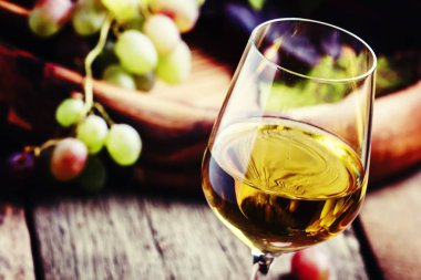 White wine in a glass with fall grapes clipart