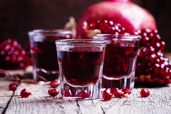Pomegranate liqueur, old wooden background — Stock Photo, Image