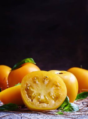 Büyük sarı domates ve fesleğen yeşil yaprakları kesti