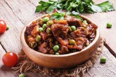 Beef stew, meat ragout with carrots, onions and green peas clipart
