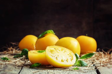 Büyük sarı domates ve fesleğen yeşil yaprakları kesti