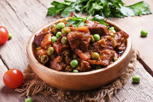 Guisado de carne, ragu de carne com cenouras, cebolas e ervilhas verdes — Fotografia de Stock