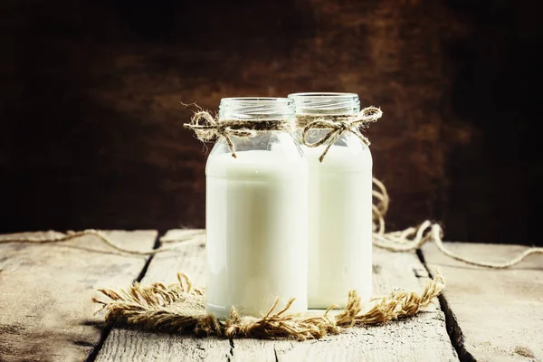 Färsk komjölk eller grädde i glasflaskor — Stockfoto