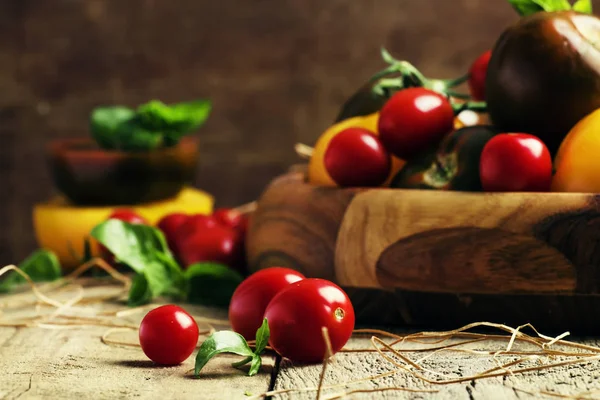 Verschillende tomaten op oude houten tafel — Stockfoto