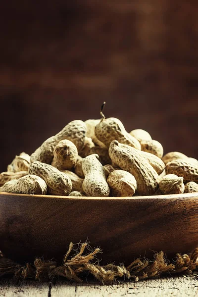 Peanuts in shell in a wooden bowl