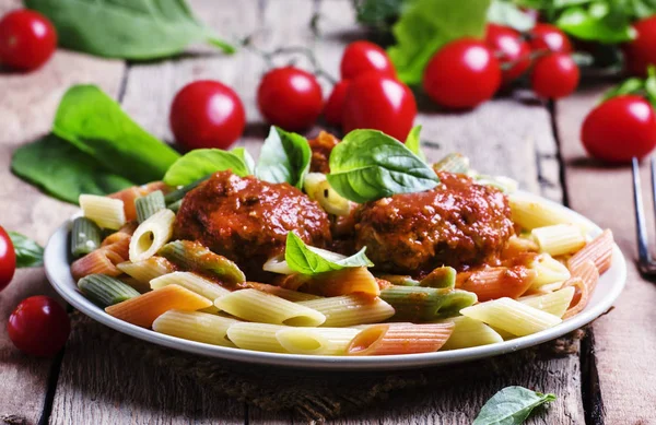 Tricolor pasta and small meatballs with tomato sauce — Stock Photo, Image
