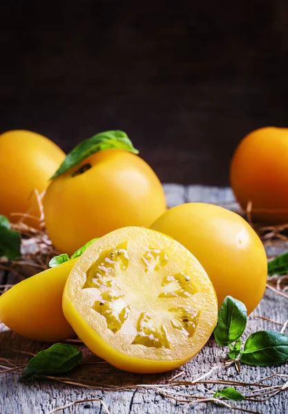 Большие желтые помидоры с базиликом — стоковое фото