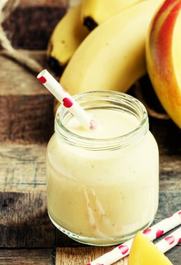 Muz mango smoothie ile Hindistan cevizi bir cam kavanozlar