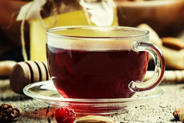 Chá preto em uma xícara de vidro com mel, frutas secas e nozes — Fotografia de Stock