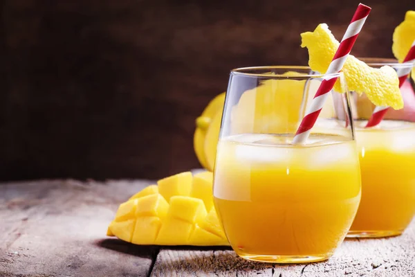 Cold mango juice with lemon and ice in glasses — Stock Photo, Image