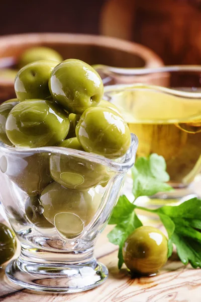 Spanische grüne Oliven in Glasschale und Olivenöl — Stockfoto