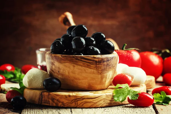 Black olives in a vintage wooden bowl — Stock Photo, Image