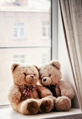 Yağmurlu bir gün üstünde belgili tanımlık pencere üzerinde kahverengi oyuncak ayılar