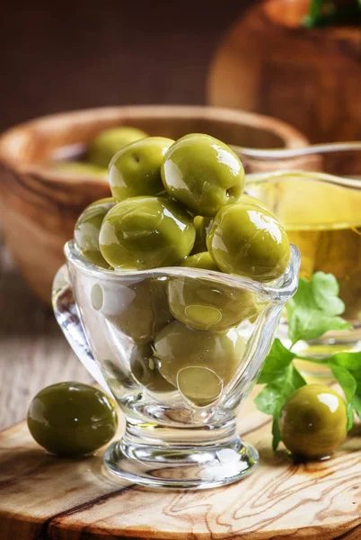 Green greek olives in glass bowl