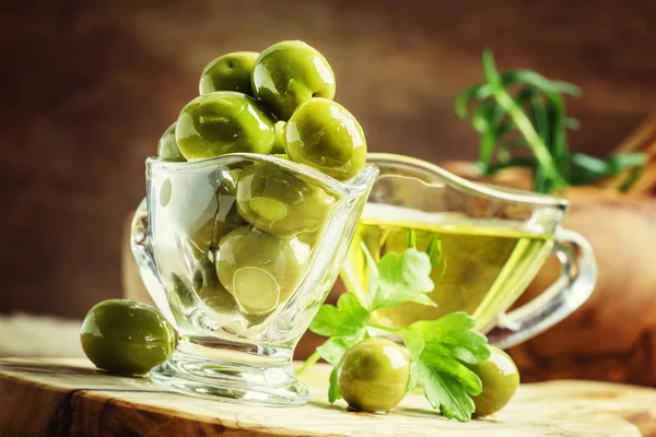 Green greek olives in glass bowl