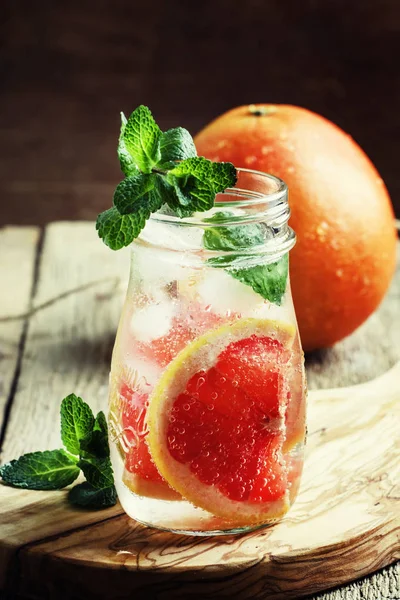 Grapefruit soda water with ice and mint leaves
